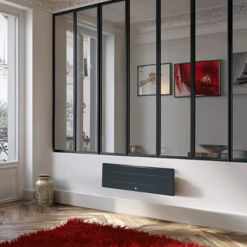 Radiateur chaleur douce Ovation 3 gris ardoise plinthe dans un salon
