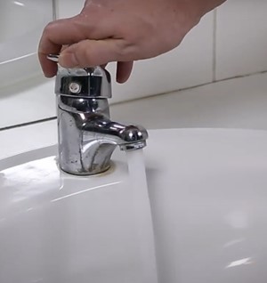 Main qui ouvre un robinet
